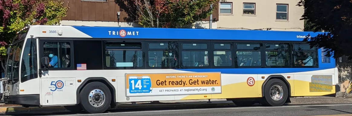 Photograph of a TriMet bus with a Consortium emergency preparedness ad along the side